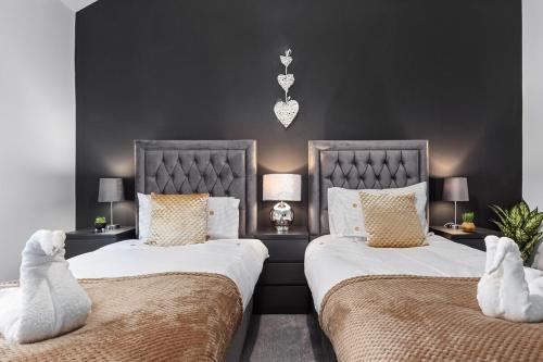 Duas camas sentadas uma ao lado da outra num quarto em Luxury by the Sea, Beautiful 3 bedroom House with Fast WiFi, King Bed, Lovely Garden! Blackpool's Finest Getaway Experience for up to 8 Guests! em Blackpool