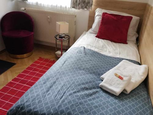 a bed with towels on it with a red pillow at Eisenerzer Apartments - Radmeisterhaus in Eisenerz