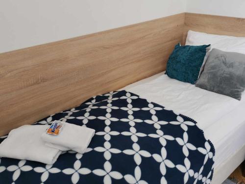 a bed with a black and white blanket and pillows at Eisenerzer Apartments - Radmeisterhaus in Eisenerz