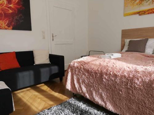 a bedroom with a bed and a couch at Eisenerzer Apartments - Radmeisterhaus in Eisenerz