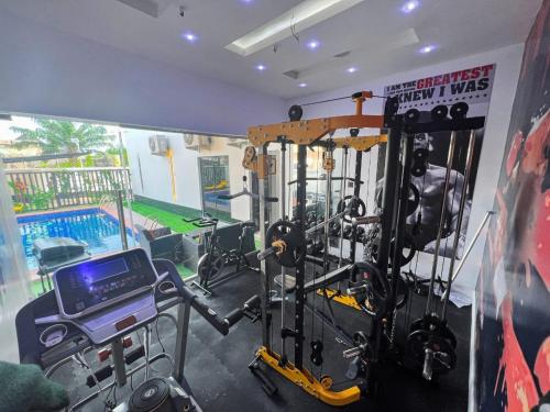 a gym with a weight room with a simulator at White Orchid in Benin City