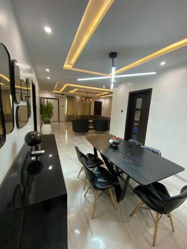 a dining room with a black table and chairs at White Orchid in Benin City