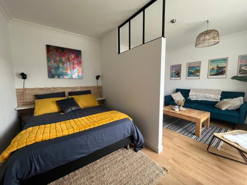 a bedroom with a bed and a couch at Cœur de Concarneau, appartement entier, proche centre, corniche et plage avec parking in Concarneau