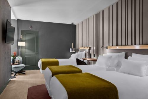 a hotel room with two beds and a television at NH Collection Amsterdam Flower Market in Amsterdam