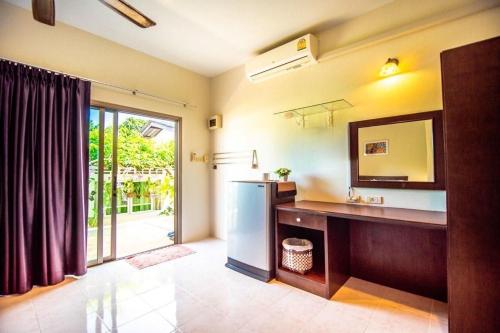 a kitchen with a refrigerator and a sink and a mirror at Muchshima House in Bang Tao Beach