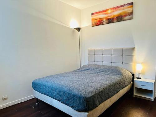 Dormitorio pequeño con cama y lámpara en Appartement lumineux près de Paris/Orly, en Courcouronnes