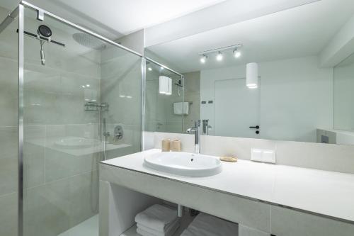 a white bathroom with a sink and a shower at Baza Sopot in Sopot