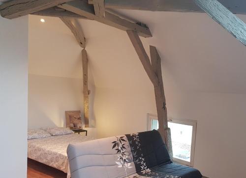 Cette chambre comprend un lit, un canapé et une fenêtre. dans l'établissement Ma Location Saisonnière, à Chasseneuil-du-Poitou
