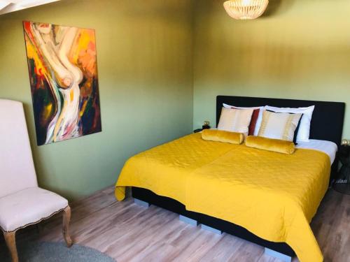 a bedroom with a yellow bed and a chair at Valkenhof in Valkenburg