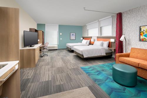 Home2 Suites by Hilton Baltimore/White Marsh في وايت مارش: غرفة فندق بسرير وتلفزيون
