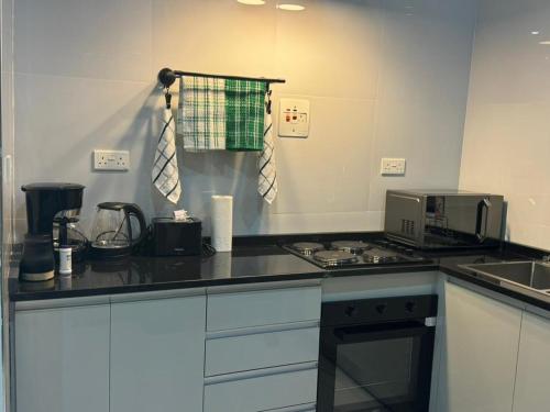 a kitchen with a counter top with a stove top oven at Modern Village Apartments in Chipata
