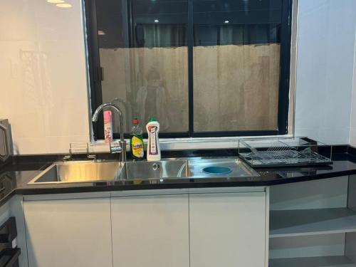 un comptoir de cuisine avec un évier et une fenêtre dans l'établissement Modern Village Apartments, à Chipata