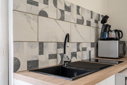 a kitchen with a sink and a counter top at Au petit chez nous in Cozes