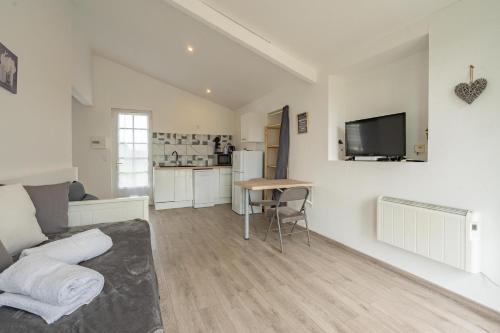 a living room with a couch and a table at Au petit chez nous in Cozes