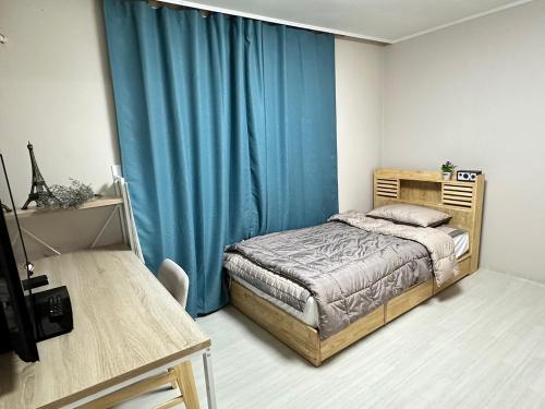 um quarto com uma cama e uma cortina azul em Memory - Internationals Only em Daegu