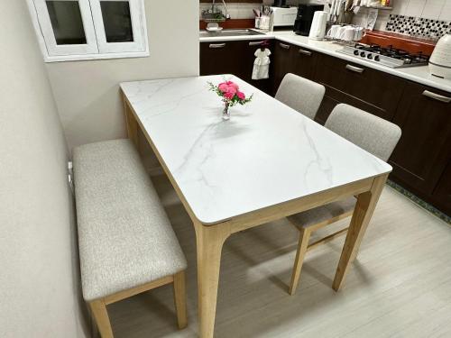 a white marble table with two chairs and a vase of flowers at Memory - Internationals Only in Daegu