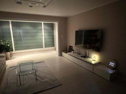 a living room with a chair and a large window at Memory - Internationals Only in Daegu
