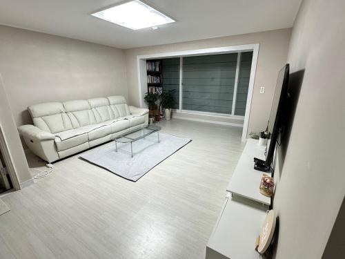 a living room with a couch and a table at Memory - Internationals Only in Daegu
