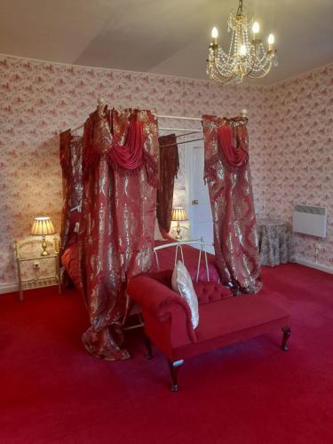 a living room with a red couch and curtains at Château Ardilleux in Ardilleux