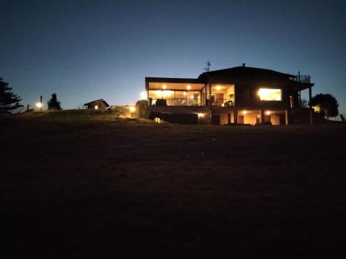 Una casa iluminada por la noche en un campo en CONFINEDEISANTI B&B APARTMENT, en Moriondo Torinese