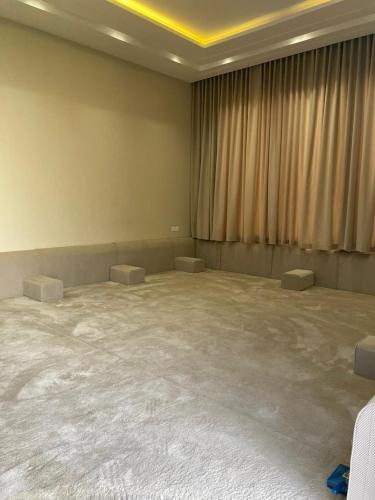 a large empty room with two tables and a curtain at شالية الفهد in Bawḑah