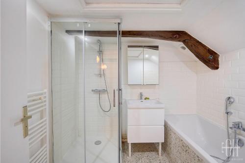 a white bathroom with a shower and a sink at Le Saint Martin / Cathédrale in Tours