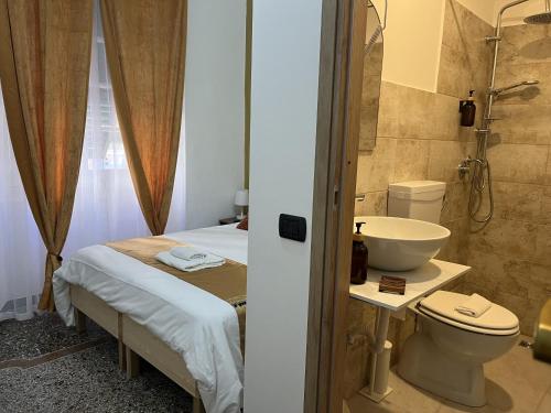 a bathroom with a bed and a toilet and a sink at Genova Gold Rooms in Genova