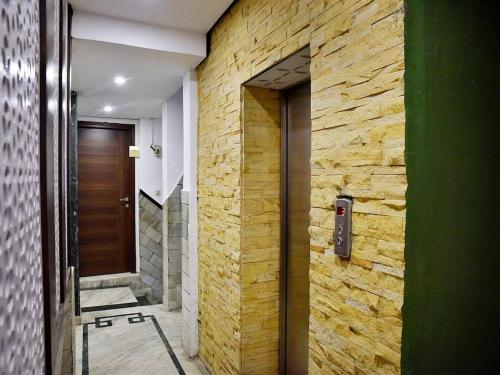 a door to a hallway with a brick wall at Ganga Hotel Near Mall Road in Shimla