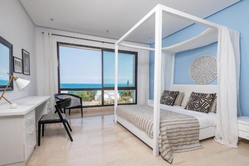 a bedroom with a white canopy bed and a desk at Villa Lord Hammon in Gammarth