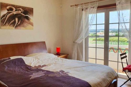 1 dormitorio con cama y ventana con vistas en Encantadora Vila perto Óbidos O Refúgio perfeito, 