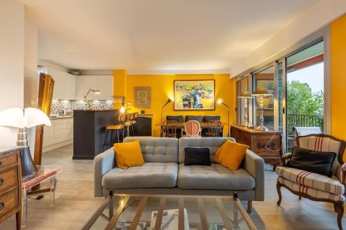 un salon avec un canapé et une cuisine dans l'établissement L'ASSOMPTION Appartement de charme avec balcon, à Paris