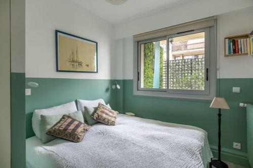 - une chambre avec un lit avec deux oreillers et une fenêtre dans l'établissement L'ASSOMPTION Appartement de charme avec balcon, à Paris
