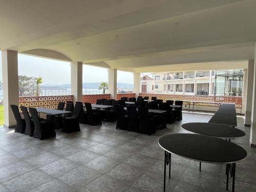 a restaurant with tables and chairs and a balcony at Narwar Lakefront Resort in Shivpurī