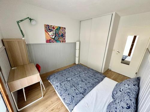 - une petite chambre avec un lit et une table dans l'établissement Appartement calme avec jardin proche de Paris, à Évry-les-Châteaux