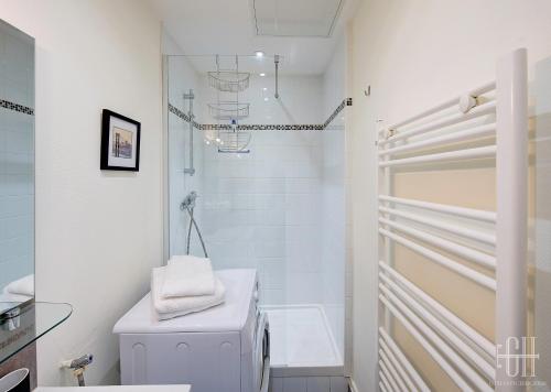 ein weißes Bad mit einem WC und einer Dusche in der Unterkunft Le Mirabeau 2 / Proche Gare in Saint-Pierre-des-Corps