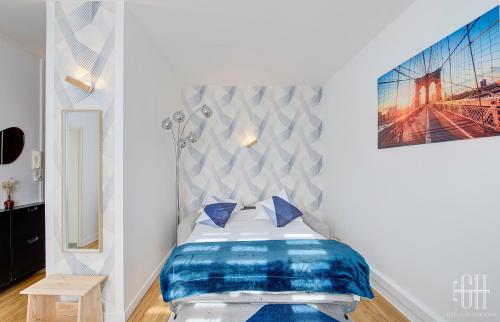 ein Schlafzimmer mit einem Bett mit blauen Kissen in der Unterkunft Le Mirabeau 2 / Proche Gare in Saint-Pierre-des-Corps
