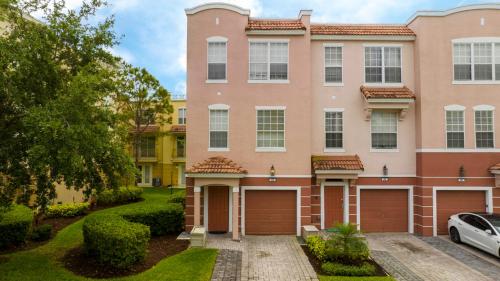 um grande edifício cor-de-rosa com duas portas de garagem em 5* House 5* Resort Orlando. Location location location em Orlando