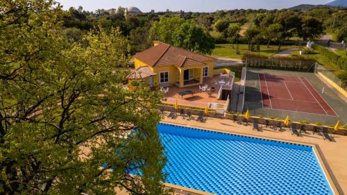 an aerial view of a house with a pool and a tennis court at Residence Mare e Sole in Taglio-Isolaccio