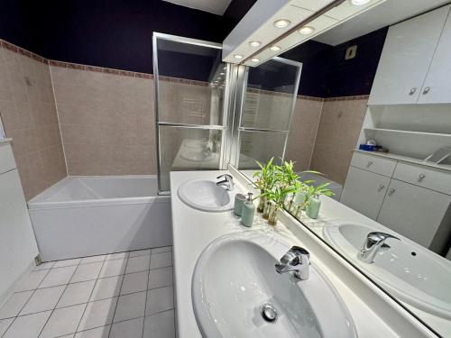 La salle de bains est pourvue d'un lavabo et d'une baignoire. dans l'établissement Appartement calme avec jardin proche de Paris, à Évry-les-Châteaux