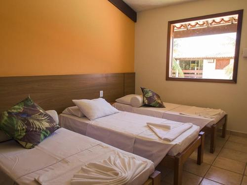 a room with three beds and a window at Apart Hotel Portal Do Atlântico - Portal Hotéis in Porto Seguro