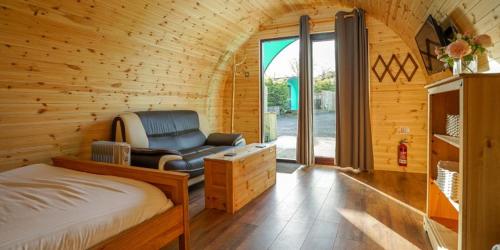 a bedroom with a bed and a chair in a room at Original Glamping Pod with Hot Tub in Frodsham
