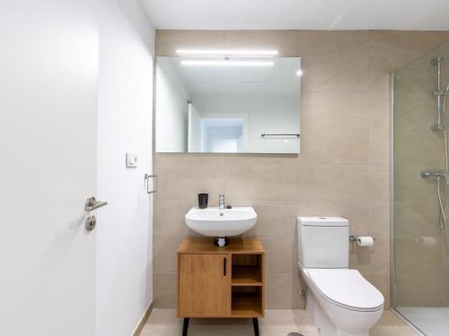 La salle de bains est pourvue d'un lavabo, de toilettes et d'un miroir. dans l'établissement Holi-Rent Pobladores, à Camas