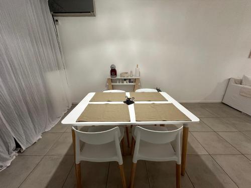 a white table with two white chairs in a room at Excellent apartment brand new in San Isidro