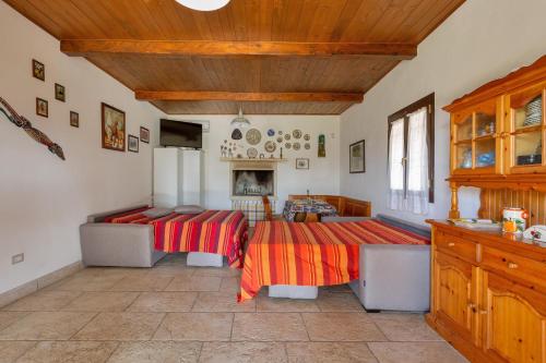 a living room with two beds and a table at Casetta Maddalena by BarbarHouse in Campi Salentina