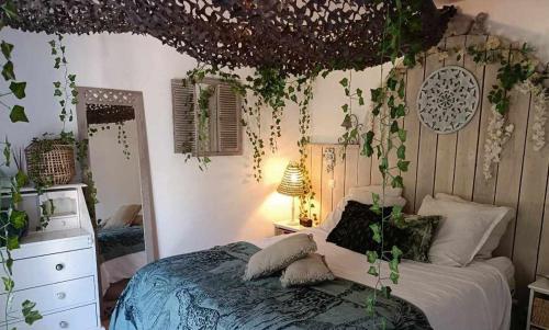 ein Schlafzimmer mit einem Bett mit Pflanzen an der Wand in der Unterkunft SIANDAKI - logement romantique de charme in La Motte