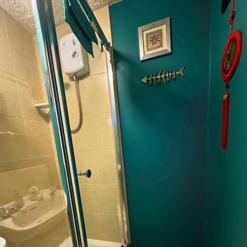 a bathroom with a shower with a sink and a mirror at Oriental Belle Aire in Hemsby