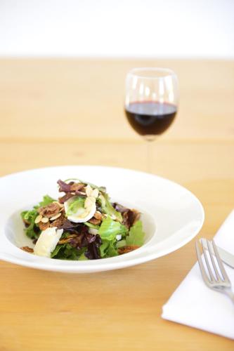 a plate of salad and a glass of wine at Herdade Do Touril in Zambujeira do Mar