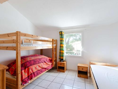 une chambre avec deux lits superposés et une fenêtre dans l'établissement Pavillon cosy 5 pers, 2 terrasses, à 150m de la plage - FR-1-409-259, à Narbonne