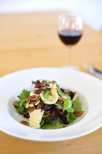 a white plate with a salad and a glass of wine at Herdade Do Touril in Zambujeira do Mar