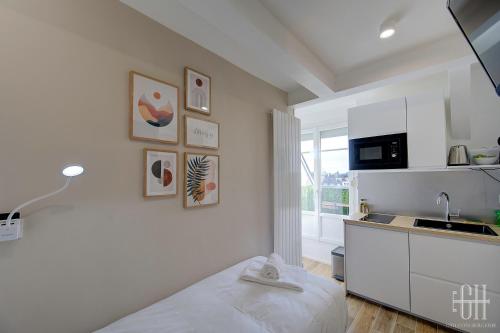 - une cuisine blanche avec un lit et un évier dans l'établissement L'Anatole / Bords De Loire, à Tours
